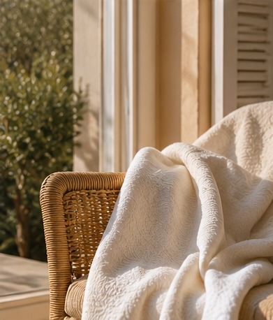 Cream throw over a woven chair by the window